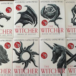 Op de afbeelding: Een set van acht paperback boeken met zwart-wit illustraties op de omslagen. De boeken maken deel uit van de "The Witcher" serie van Andrzej Sapkowski. De titels zijn "De laatste wens", "Zwaard van het lot", "Het bloed van de elven", "De tijd van de minachting", "Doop van vuur", "De toren van de zwaluwen", "De dame van het meer" en "Seizoen van stormen".