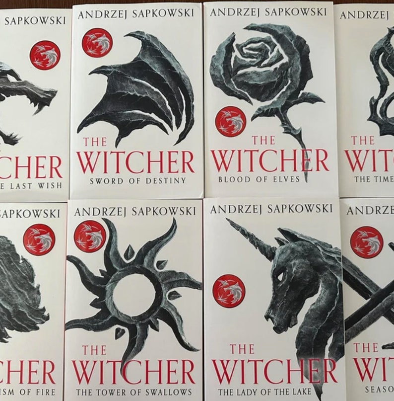 Op de afbeelding: Een set van acht paperback boeken met zwart-wit illustraties op de omslagen. De boeken maken deel uit van de "The Witcher" serie van Andrzej Sapkowski. De titels zijn "De laatste wens", "Zwaard van het lot", "Het bloed van de elven", "De tijd van de minachting", "Doop van vuur", "De toren van de zwaluwen", "De dame van het meer" en "Seizoen van stormen".
