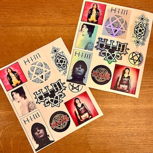 May include: Two sheets of stickers featuring the band HIM. The stickers are black and white with a pentagram design and the band's name. There are also stickers with images of the band members.