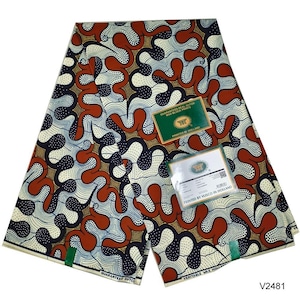 May include: A folded piece of fabric featuring a repeating pattern of wavy, interlocking shapes in rust orange, dark navy blue, and cream. The design includes dotted textures and two rectangular labels reading Guaranteed Real Dutch Wax Block Prints and Printed by Vlisco in Holland.