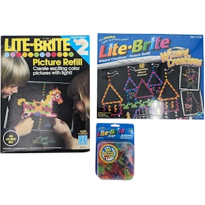 May include: Three Lite-Brite sets. One box shows a horse design, the other a castle design. A package of 40 pegs is also included. The boxes read "Picture Refill" and "Create exciting color pictures with light!"