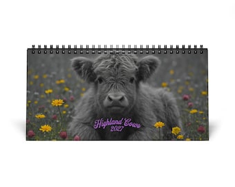 May include: A horizontal spiral-bound wall calendar featuring a black and white photograph of a Highland calf lying in a field of yellow and pink wildflowers. The text Highland Cows 2027 is printed in purple script across the lower center.
