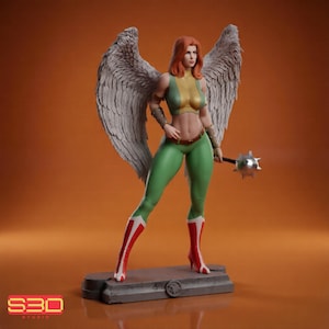 Puede incluir: Figura detallada de una superheroína con grandes alas de plumas. Viste un traje verde y amarillo, botas rojas y sostiene una maza con púas. La figura está sobre una base gris sobre un fondo naranja.