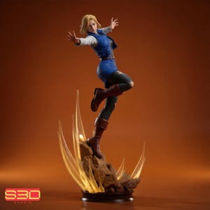 May include: A collectible figurine of a blonde character in a dynamic pose, wearing a blue vest over a white long-sleeve shirt, a blue skirt, and black leggings with brown boots. The figure stands on a rocky base with translucent yellow energy effects.