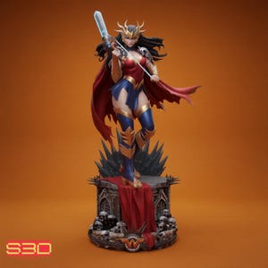 May include: A detailed figurine of a female superhero in a dynamic pose, clad in a red, blue, and gold costume. She holds a glowing blue weapon and stands atop a gothic-style base with skulls and a red drape. The figure has a golden crown and a red cape.