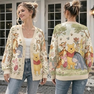 May include: A cream-colored button-down cardigan featuring a repeating pattern of Winnie the Pooh characters including Tigger, Eeyore, Piglet, and Pooh Bear. The knit garment displays colorful illustrations of the characters amidst trees and flowers.