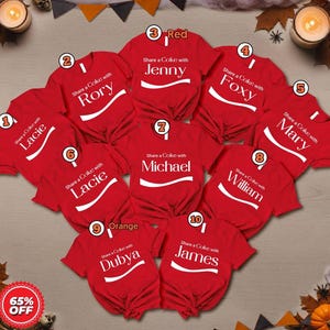 May include: Ten red short-sleeved t-shirts arranged in a heart shape. Each shirt features the white text "Share a Coke with" followed by a unique name: Lacie, Rory, Jenny, Foxy, Mary, Lacie, Michael, William, Dubya, and James, with a white swoosh.