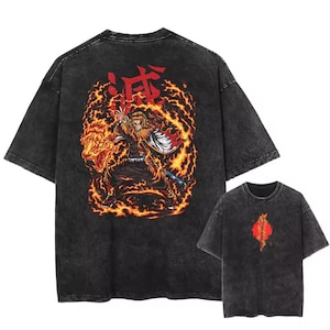 May include: Dark gray t-shirt featuring a vibrant graphic of a character engulfed in flames, with Japanese text at the top. A smaller version of the shirt is visible below. The design includes shades of red, orange, and yellow.