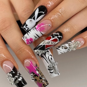 May include: Long acrylic nails with diverse designs. One nail displays a Playboy bunny, another a heart with "LOVE" and "KILL" text. Other nails feature pink accents, leopard print, and silver embellishments.