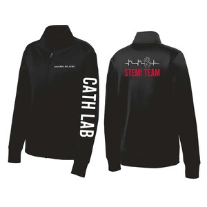 May include: Black zip-up jacket with white text "CATH LAB" on the left sleeve. The front has small text, and the back features a heart graphic and the words "STEMI TEAM" in red. A medical-themed jacket.