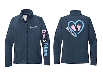 May include: Navy blue full-zip jacket with the text "Jessica, RN" on the chest and "Labor & Delivery" on the sleeve. The back features a blue heart with baby footprints and the words "Labor & Delivery".