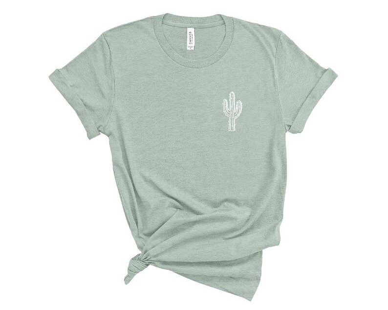 Puede incluir: Una camiseta verde claro con un contorno blanco de un cactus en la parte delantera.
