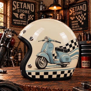 Può includere: Un casco da moto aperto color crema con la grafica di uno scooter Vespa azzurro, un motivo a scacchi bianco e nero lungo il bordo inferiore e bottoni a pressione in metallo argentato sul lato per fissare una visiera o un accessorio.