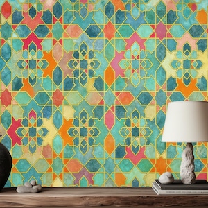 Può includere: Una scena decorativa con una carta da parati a motivi geometrici colorati in verde acqua, arancione, rosa e giallo. Un vaso grigio scuro, una lampada bianca con paralume beige e una pila di libri sono su una superficie di legno.
