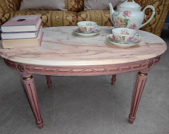 Mesa de centro estilo Luis XVI con tablero de mármol Calacatta y estructura rosa antigua con detalles dorados/plateados.
