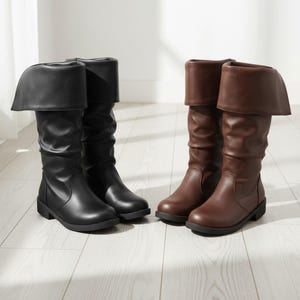 May include: Two pairs of knee-high boots. One pair is black, the other is brown. Both pairs have a folded-over cuff at the top and a low heel. The boots are made of a smooth material and are displayed on a light-coloured wooden floor.