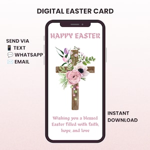 May include: A smartphone displaying a digital Easter card with the text HAPPY EASTER and Wishing you a blessed Easter filled with faith, hope, and love. The card features a wooden cross decorated with pink and white flowers and greenery.
