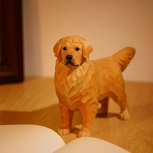 May include: A detailed wooden sculpture of a Golden Retriever dog. The dog is carved with visible wood grain and texture, showcasing the craftsmanship. The sculpture is in a standing pose with its tail up, and the color is a warm, natural wood tone.