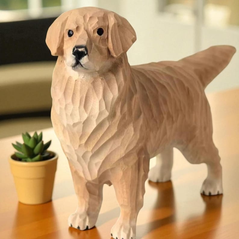 May include: A carved wooden sculpture of a Golden Retriever dog. The dog is light brown with detailed carved fur and white paws. The dog is standing on a wooden surface. A small potted succulent plant is in the background.