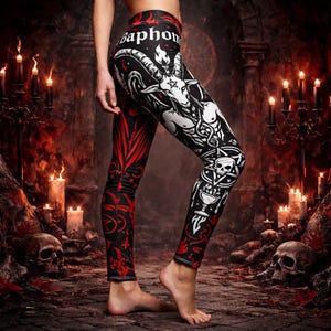 Puede incluir: Leggings negros con un diseño gráfico rojo y blanco. Los leggings presentan una ilustración de Baphomet, un pentagrama y la palabra "Baphom" en la cintura. El diseño incluye una calavera, un cáliz y otros elementos góticos.