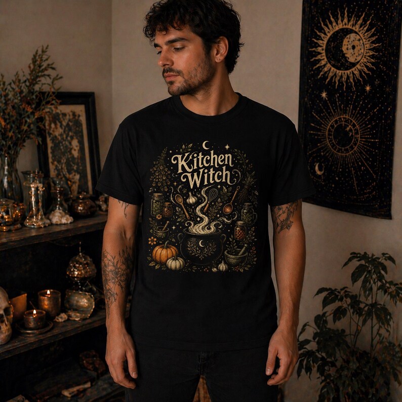 Kitchen Witch shirt featuring a vintage cottagecore folk magic design with herbal cauldron, mystical herbs, stars, and botanical details. Witchy unisex tee inspired by kitchen witchcraft, pagan spirituality, herbalism, and cozy mystical aesthetics. Perfect gift for witches, herbalists, cottagecore lovers, Wiccan fashion fans, and botanical magic enthusiasts.