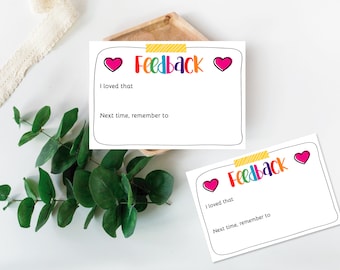 May include: Two white cards with black outlines and a colorful "Feedback" title. Each card has a pink heart on either side of the title. The text "I loved that" and "Next time, remember to" are printed on each card.