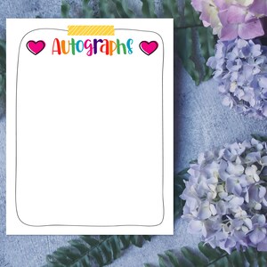 May include: A white printable sheet with a black border and the text "Autographs" in rainbow colors. Two pink hearts are on either side of the text. The sheet is on a blue and gray textured background with pink and purple flowers.