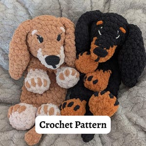 Puede incluir: Dos peluches de perro salchicha de ganchillo, uno marrón y otro negro, con detalles en naranja y blanco. Los peluches tienen orejas grandes y caídas y almohadillas. El texto "Crochet Pattern" se muestra en un rectángulo blanco.