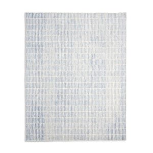May include: Rectangular area rug with a textured pattern of vertical lines in shades of light blue and white. The rug has a soft, neutral color palette, suitable for various interior design styles.
