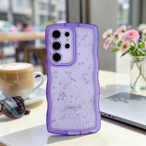 Könnte beinhalten: Ein Set aus drei Keramikbechern mit gesprenkelter, matter Oberfläche. Die Becher sind in den Farbtönen Creme, Hellgrau und Dunkelgrau gehalten. Jeder Becher hat ein schlichtes, minimalistisches Design und einen abgerundeten Henkel. Die Becher sind aufeinander gestapelt.