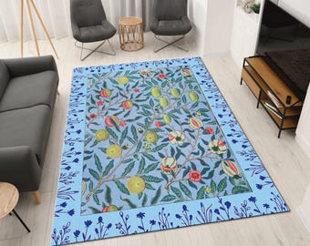 May include: A rectangular area rug with a light blue background and a floral pattern. The rug features a border with a dark blue floral design. The central pattern includes green, yellow, and red fruits and flowers.