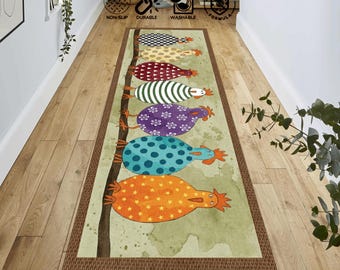 Può includere: Un tappeto rettangolare decorativo con un design stravagante di galline stilizzate in vari modelli e colori, tra cui arancione, blu e viola. Il tappeto ha un bordo marrone ed è posto su un pavimento in legno. Il tappeto è antiscivolo, resistente e lavabile.