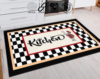 May include: Kitchen mat with a black and white checkered border and a central cream-colored rectangle. The rectangle features the word "Kitchen" in a script font and an illustration of a chef. The mat has a black border.