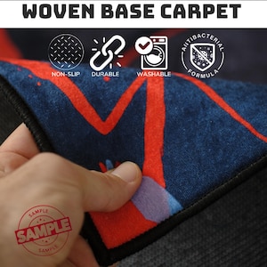 May include: Close-up of a woven base carpet with a navy blue background and red abstract design. The carpet is labeled as non-slip, durable, washable, and antibacterial. The word "SAMPLE" is stamped on the carpet.