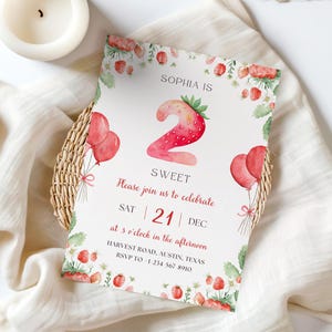 Puede incluir: Una invitación de cumpleaños con temática de fresas. La invitación presenta un gran número "2" diseñado como una fresa, con el texto "Sophia is Sweet". Globos rojos e ilustraciones de fresas decoran el borde.