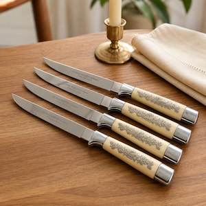 May include: A set of four Solingen Baron stainless steel knives with cream-colored handles featuring an embossed floral pattern. Each knife blade is engraved with the text Solingen Baron Germany Stainless Steel and has a polished metal bolster.