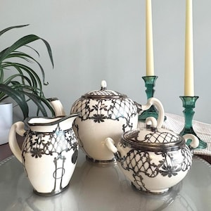 May include: A set of three ceramic mugs with a speckled, matte finish. The mugs are in shades of cream, light gray, and dark gray. Each mug has a simple, minimalist design, perfect for coffee or tea.