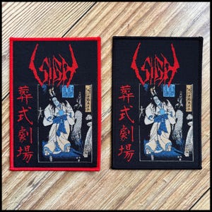 May include: Two rectangular patches with a black background. One has a red border, the other a black border. Both feature a red stylized logo above a Japanese-style illustration of a figure in white and blue robes. Japanese text is below.