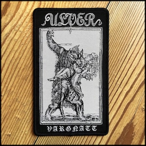 May include: Black and white patch featuring a detailed illustration of a wolf-like creature carrying a person. The patch has the word "ULVER" at the top and "VARGNATT" at the bottom, both in a gothic font.