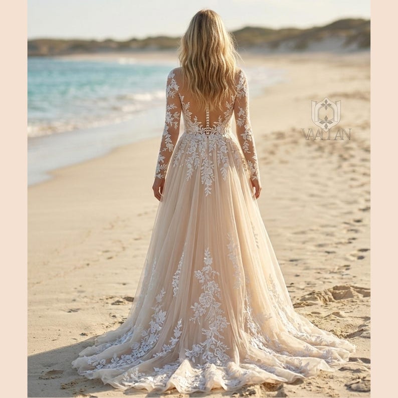 Pu&ograve; includere: Un abito da sposa lungo fino a terra con maniche lunghe e schiena trasparente, caratterizzato da intricati ricami in pizzo floreale bianco su tessuto beige chiaro. L'abito ha un corpetto aderente e una gonna fluida con strascico, con il logo Vaallan.
