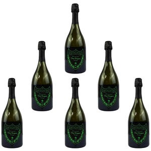 May include: Seven green champagne bottles with black caps are arranged against a white background. Each bottle has a dark green label with white and green text and a decorative emblem. The bottles are evenly spaced and angled.
