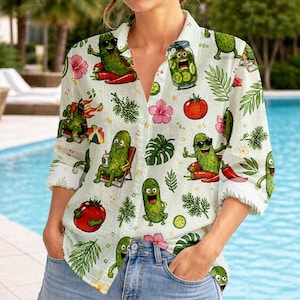 May include: Light green button-down shirt with a fun pickle print. The shirt features cartoon pickles wearing sunglasses, sitting in beach chairs, and enjoying themselves. Red chili peppers, pink flowers, and tomatoes are also part of the design.
