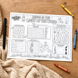 May include: A white activity placemat featuring the text "JESUS IS THE LIGHT OF THE WORLD" and various puzzles and activities. The placemat is accompanied by coloured crayons and a black pen. The activities include a maze, word search, and drawing prompts.