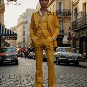 May include: A three-piece yellow suit with wide-leg pants. The suit includes a jacket, vest, and trousers. The man is standing on a cobblestone street. The suit is a solid color with a classic design.