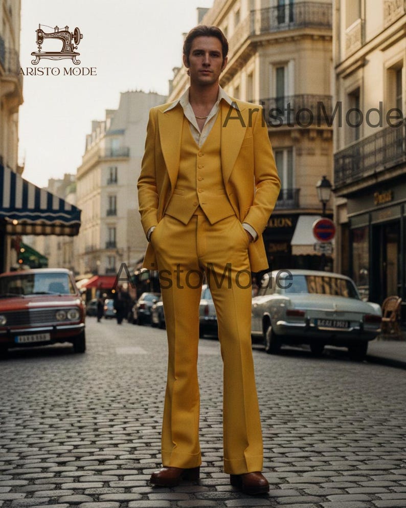 May include: A three-piece yellow suit with wide-leg pants. The suit includes a jacket, vest, and trousers. The man is standing on a cobblestone street. The suit is a solid color with a classic design.