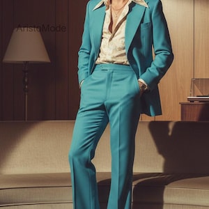 May include: A teal suit with a matching jacket and flared pants. The jacket is worn over a patterned shirt. The image features a retro aesthetic, with a mid-century modern sofa and a lamp in the background. The suit is a vibrant color.