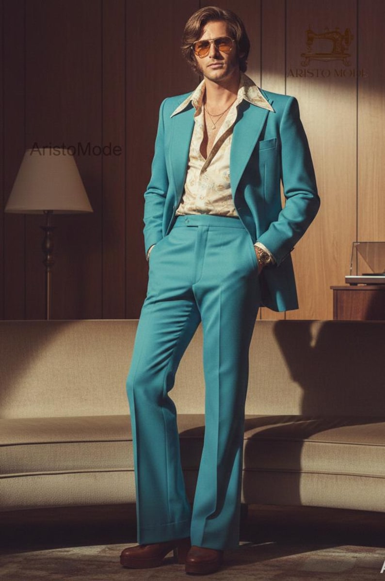 May include: A teal suit with a matching jacket and flared pants. The jacket is worn over a patterned shirt. The image features a retro aesthetic, with a mid-century modern sofa and a lamp in the background. The suit is a vibrant color.