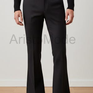 May include: Black flared trousers with a tailored fit. The pants have a high waist and a wide leg, with a classic design. The image also shows a black long-sleeve shirt.