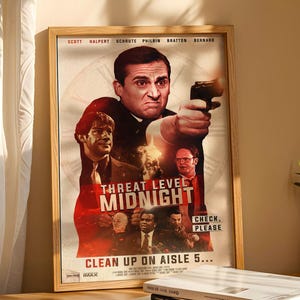 Puede incluir: Un póster enmarcado con el título "Threat Level Midnight" y el texto "Clean Up On Aisle 5...". El póster presenta a un hombre sosteniendo un arma, con otras caras en el fondo. El póster está en un marco de madera.