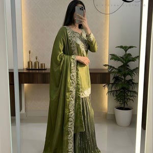 Peut inclure: Ensemble vert olive compos&eacute; d'une tunique &agrave; manches longues, d'un pantalon large et d'un ch&acirc;le assorti. La tenue est orn&eacute;e de broderies complexes sur les bords et les poignets. L'ensemble est fait d'un tissu doux et fluide.